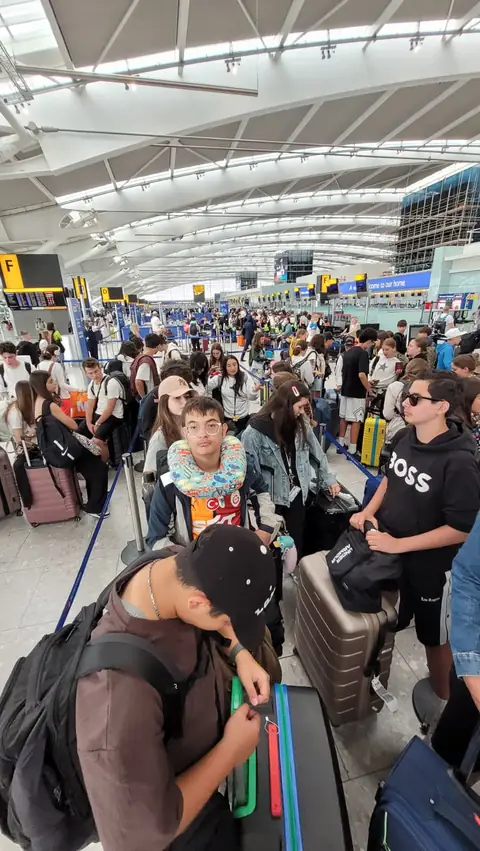 Havalimanında check-in sırasında bekleyen öğrenciler