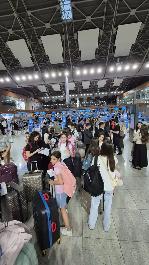 Dış hatlar gidiş salonunda valizleriyle öğrenciler