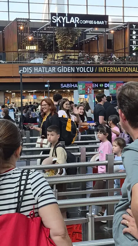 Dış hatlar gidiş kapısında sıra bekleyen öğrenciler