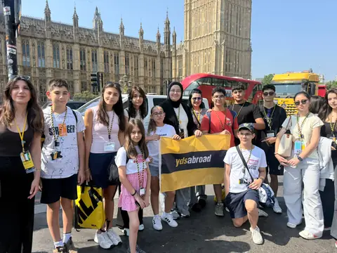 Big Ben önünde pankartla poz veren öğrenciler