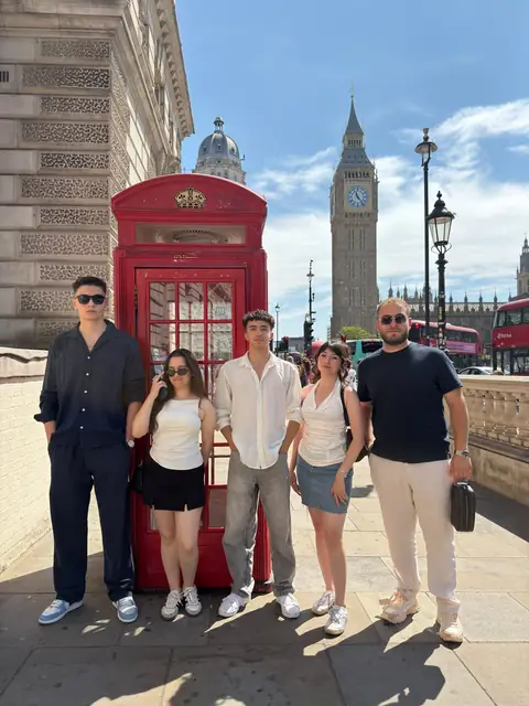 Big Ben ve kırmızı telefon kulübesinin önünde bir grup