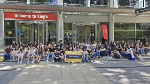 King's College London girişinde oturan öğrenci grubu