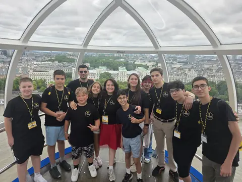 London Eye kapsülünde şehir manzarası önünde öğrenciler