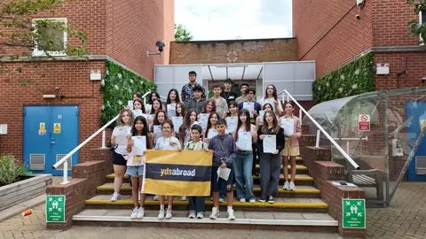 Merdivenlerde pankart ve sertifikalarla toplu fotoğraf