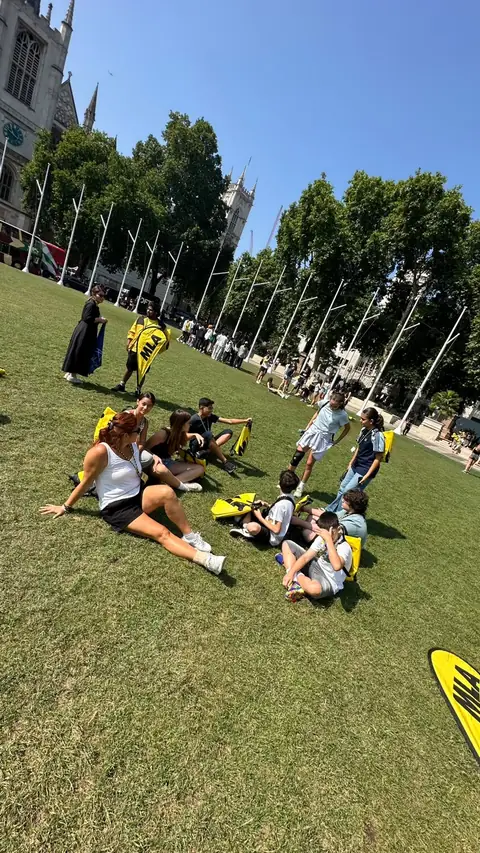 Çimenlerde oturup mola veren öğrenciler
