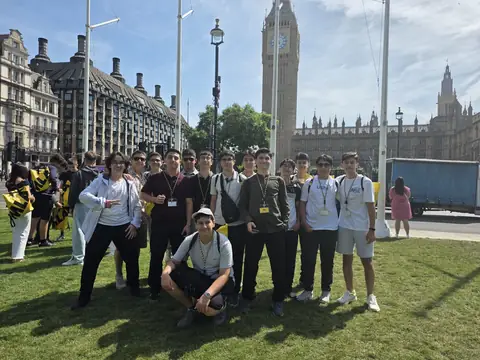 Big Ben önünde çimenlikte poz veren öğrenciler