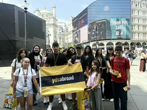 Piccadilly Circus'ta pankartla poz veren öğrenciler