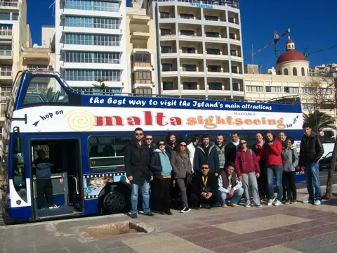 Malta'da tur otobüsünün önünde öğrenciler