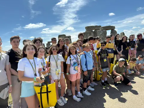 Stonehenge önünde gülümseyen öğrenciler