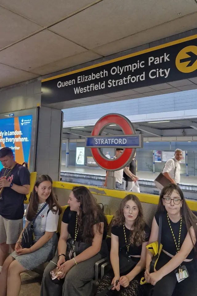Londra Stratford metro peronunda bankta oturan öğrenciler