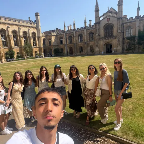 Cambridge'de tarihi kolej avlusunda grup özçekimi
